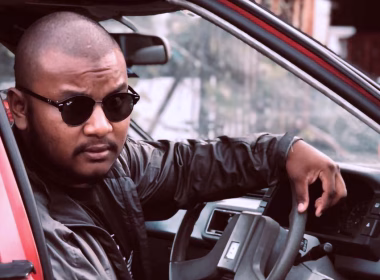 CEO Batu duduk di dalam kereta dengan memakai cermin mata hitam dan jaket hitam