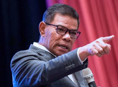 Saifuddin Nasution sedang berucap sambil menunjuk jari ke hadapan, dengan ekspresi tegas.