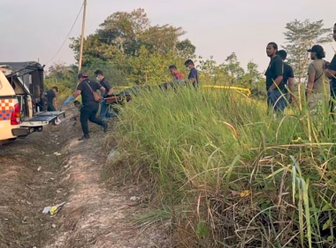 Pasukan forensik dan polis mengangkat mayat dari lokasi semak di Jempol, berhampiran trak forensik di laluan tanah merah.