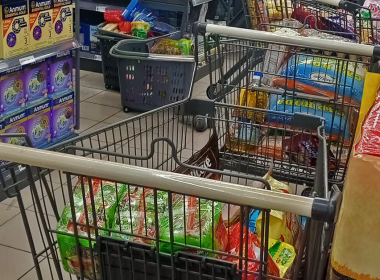 Seorang lelaki meletakkan semula susu bayi di rak pasar raya selepas sistem bantuan MyKasih tergendala.
