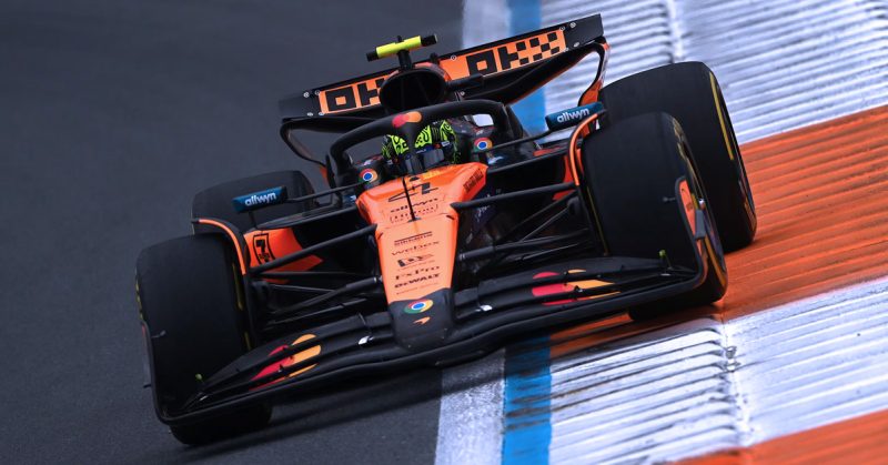 Kereta McLaren F1 berwarna oren laju membelok di litar Zandvoort semasa sesi latihan Grand Prix Belanda.