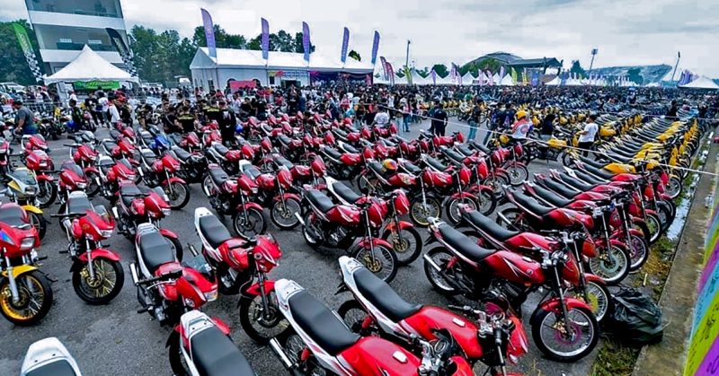 Deretan motosikal Yamaha RXZ berwarna merah dan kuning tersusun rapi di kawasan parkir terbuka, dipenuhi peserta dan pengunjung acara RXZ Member 6.0.