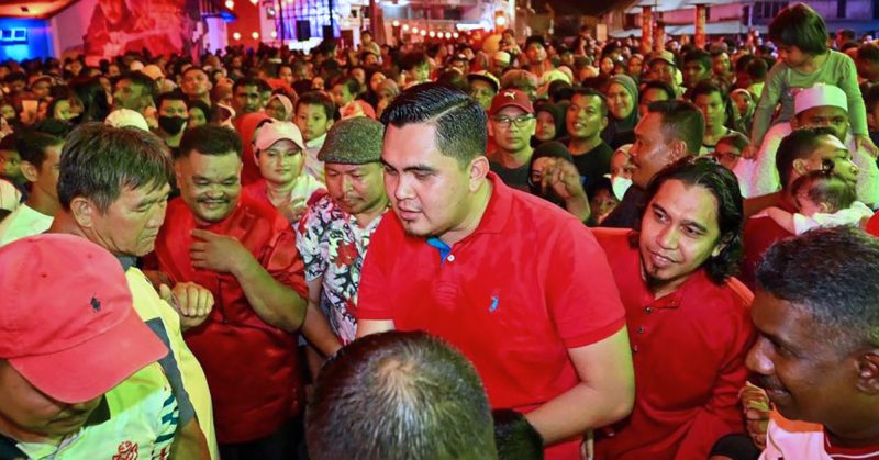 Akmal Saleh berbaju merah berada di tengah orang ramai ketika menghadiri sebuah program malam.