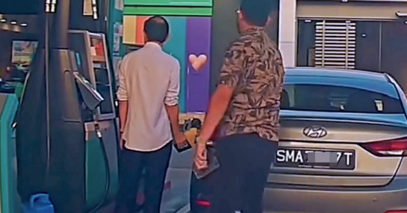 Seorang lelaki menegur pemandu kereta bernombor pendaftaran Singapura yang sedang mengisi minyak di stesen petrol.