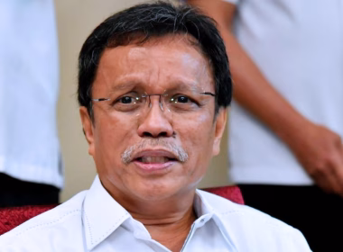 Shafie Apdal bercakap kepada media dengan latar belakang individu berpakaian putih.