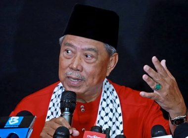 Tan Sri Muhyiddin Yassin berucap pada sidang media, mengenakan baju merah dan songkok hitam, ketika diumumkan sebagai calon Perdana Menteri ke-11 oleh Bersatu.