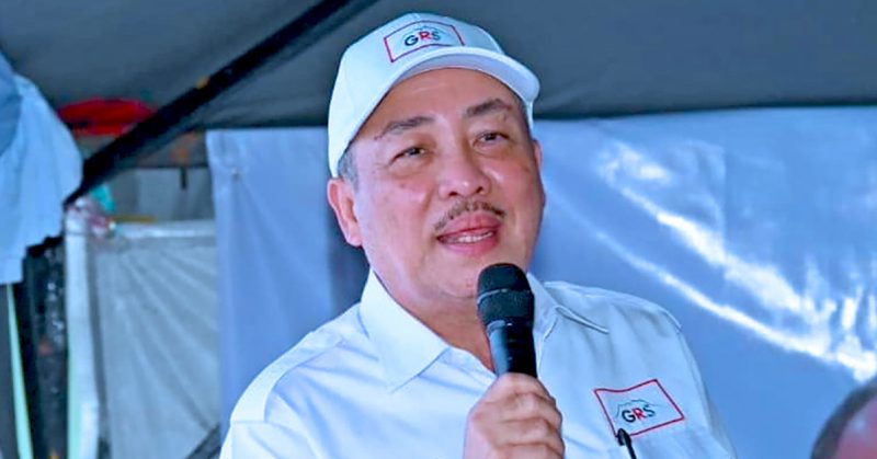 Hajiji Noor berucap dengan memakai topi dan baju GRS, pegang mikrofon ketika majlis.
