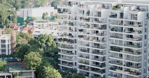 Pemandangan sebuah kondominium moden bertingkat tinggi dengan balkoni penuh tanaman hijau, menggambarkan gaya hidup urban yang sering diiklankan.