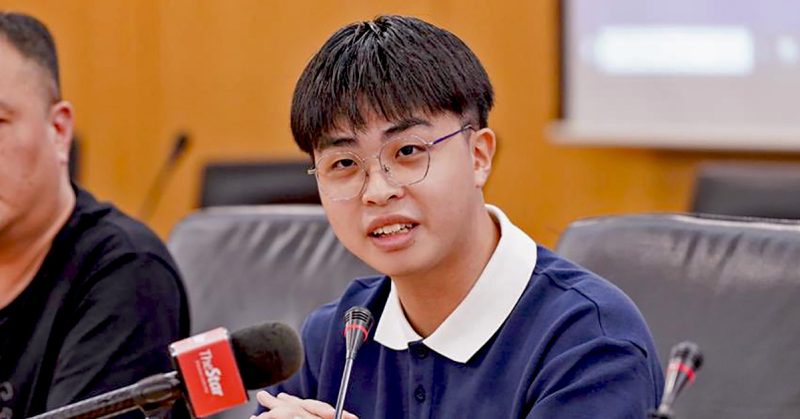 Seorang pelajar STPM, Edward Wong, bercakap pada sidang media dengan mikrofon di depannya.