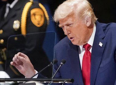 Donald Trump berucap dengan penuh semangat di pentas PBB, memakai sut biru gelap dan tali leher merah.