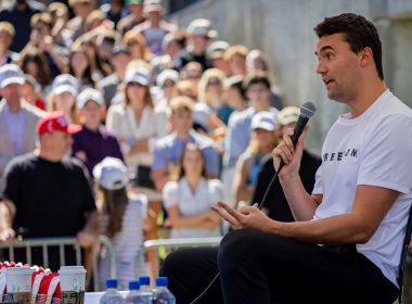 Charlie Kirk berucap di hadapan orang ramai di sebuah acara kampus sambil memegang mikrofon.