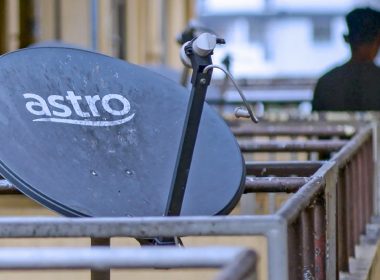 Pinggan satelit Astro dipasang di balkoni flat, melambangkan isu pemotongan langganan Astro yang semakin meningkat.