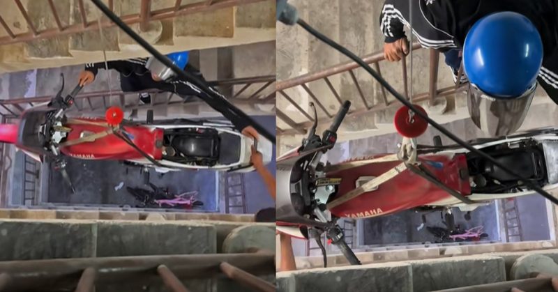 Motosikal RXZ dinaikkan menggunakan electric hoist ke rumah flat dengan bantuan rakan-rakan