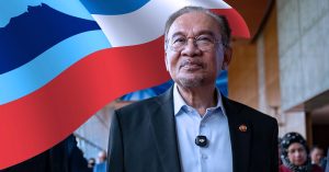 Perdana Menteri Malaysia Datuk Seri Anwar Ibrahim berdiri di hadapan latar bendera Sabah, melambangkan komitmen Kerajaan MADANI terhadap MA63 dan peningkatan Pemberian Khas Sabah.