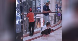 Seorang anak perempuan OKU duduk mencangkung di pusat beli-belah sambil ditemani keluarga, mencetus isu layanan terhadap OKU.