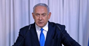 Benjamin Netanyahu berucap di podium dalam sidang media, mengenakan sut gelap dan tali leher biru, simbolik kepada kenyataan tegas Israel mengenai kekuatan dan keamanan.
