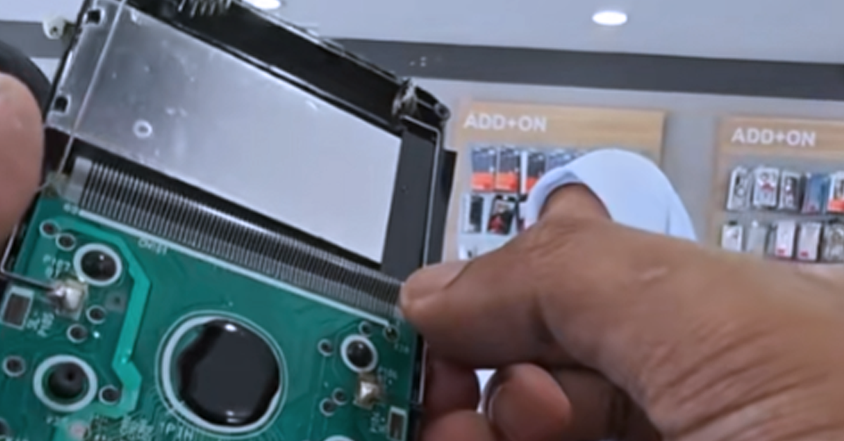 Peniaga menunjukkan proses membaiki kalkulator saintifik yang rosak akibat air di sebuah kedai di Kota Bharu.