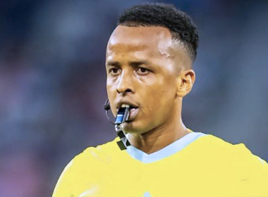 Omar Artan meniup wisel ketika mengadili perlawanan bola sepak antarabangsa