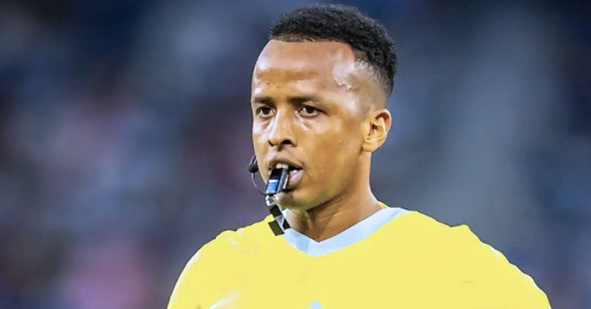 Omar Artan meniup wisel ketika mengadili perlawanan bola sepak antarabangsa