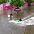 Lelaki menaiki jet ski di jalan raya yang dinaiki air ketika banjir di Bangkok.
