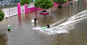 Lelaki menaiki jet ski di jalan raya yang dinaiki air ketika banjir di Bangkok.