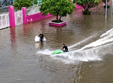 Lelaki menaiki jet ski di jalan raya yang dinaiki air ketika banjir di Bangkok.