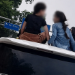 Dua kanak-kanak duduk di atas Toyota Alphard ketika kenderaan sedang bergerak di jalan raya