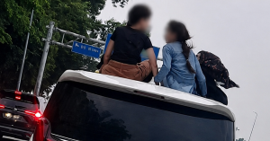 Dua kanak-kanak duduk di atas Toyota Alphard ketika kenderaan sedang bergerak di jalan raya
