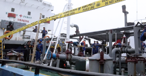Anggota polis Indonesia mengawal sebuah kapal tangki yang dipasang pita keselamatan polis.